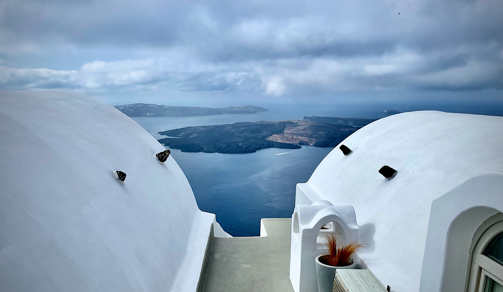 Santorini, looking past houses into the volcanic caldera.